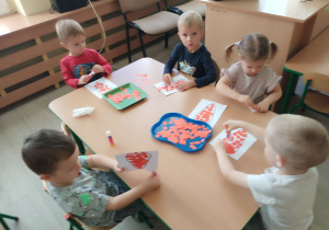 Dzieci wyklejają marchewkę